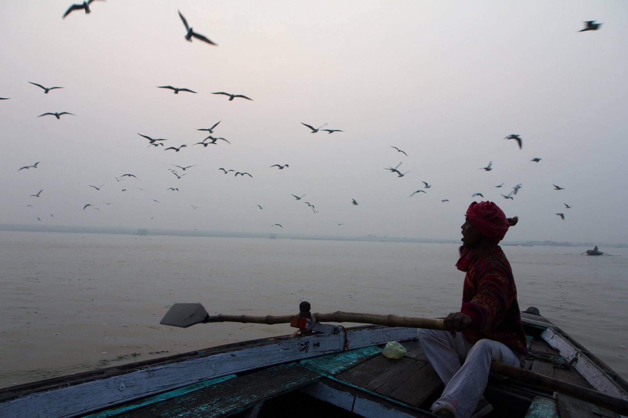 Onze bootsman op de Ganges roept de vogels